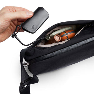 Bellroy Lite Sling Mini in black showing key clip attached inside compact crossbody bag pocket