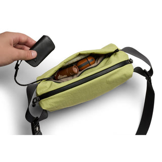 Bellroy Lite Sling Mini in light green showing spacious interior with small accessories inside and black strap