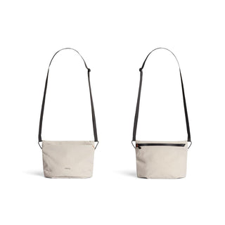 Bellroy Lite Sacoche crossbody bag in light beige recycled fabric with adjustable black strap shown front and back views