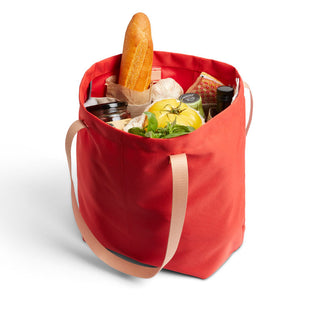 Bellroy Market Tote in red recycled nylon filled with groceries including bread and fresh produce