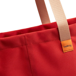 Bellroy Market Tote close-up showing red recycled nylon fabric and beige handles with logo tag