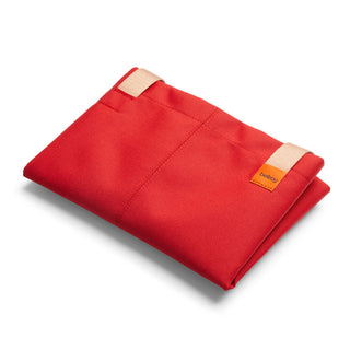 Bellroy Market Tote folded flat in vibrant red recycled nylon with beige handles and logo patch