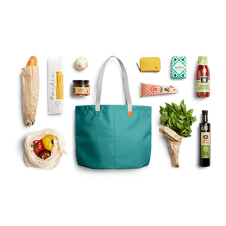 Bellroy Market Tote in teal with grey handles surrounded by groceries on white background