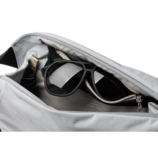 Bellroy Venture Sling 6L in light gray showing organized interior with sunglasses and zippered pocket