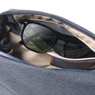 Bellroy Venture Sling 6L in textured gray fabric showing internal beige lining with black sunglasses inside pocket