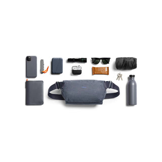 Bellroy Venture Sling 6L in charcoal fabric laid flat with everyday carry items around it