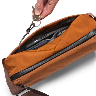 Bellroy Venture Sling 6L in burnt orange showing internal organizer pocket with keyring attachment