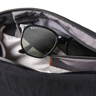 Bellroy Venture Sling 6L in black fabric showing interior zip pocket holding sunglasses and small items