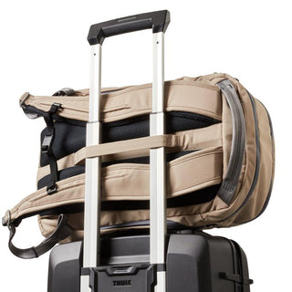Bellroy Transit Workpack Pro 22L in tan fabric hooked on suitcase handle with padded shoulder straps visible