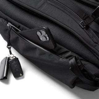 Bellroy Transit Workpack Pro 28L black backpack showing side zip pocket holding a smartphone and keys