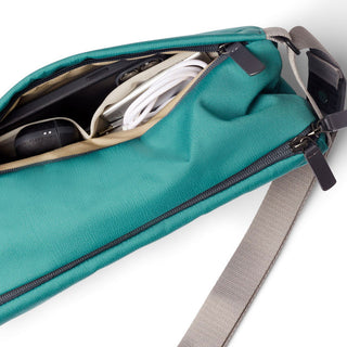 Bellroy Sling - 7L in teal with durable fabric and organized interior compartments shown with accessories inside