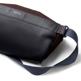 Bellroy Sling Mini Premium - 7L in black leather with brown fabric and adjustable navy strap close-up view
