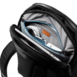Bellroy Transit Backpack in black showing organized compartments with tech gadgets and cables inside