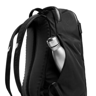 Bellroy Transit Backpack in black with padded straps and side pocket holding a silver water bottle