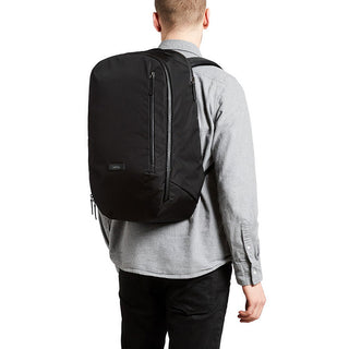 Bellroy Transit Backpack worn by a man, showing smooth black woven fabric and slim profile back view