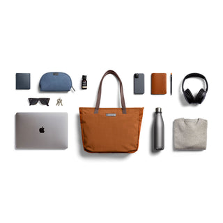 Bellroy Tokyo Tote Compact in rust with water-resistant fabric and brown leather handles displayed with essentials