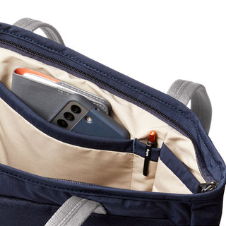 Bellroy Tokyo Tote Compact showing navy water-resistant interior pockets with phone and notebook inside