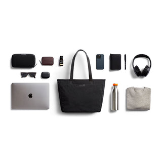 Bellroy Tokyo Tote Compact black woven fabric bag styled with everyday tech and accessories laid flat