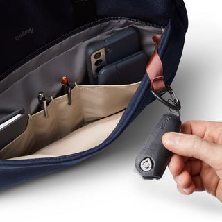 Bellroy Via Work Bag (Tech Briefcase) navy interior with organized pockets holding tech and pens, hand attaching key clip