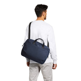 Bellroy Via Work Bag (Tech Briefcase) navy blue fabric with black handles worn crossbody by man