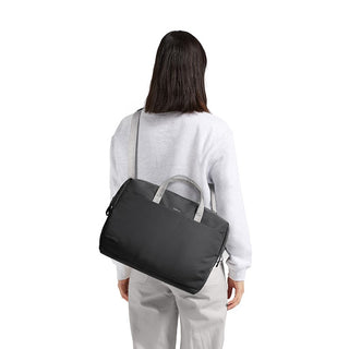 Bellroy Via Work Bag (Tech Briefcase) in black nylon carried crossbody on model’s back with gray handles