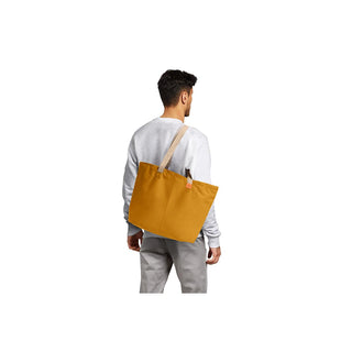 Bellroy Market Tote in mustard yellow recycled nylon carried on shoulder by man in casual outfit