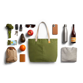 Bellroy Market Tote in olive green with beige handles, shown with everyday essentials on white background