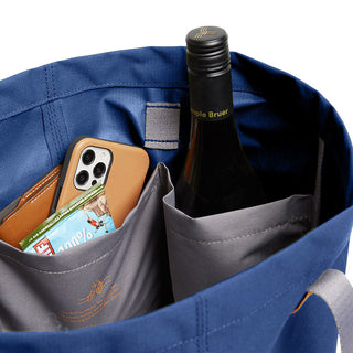 Bellroy Market Tote in blue showing interior pockets with bottle, phone, and snack bar compartments