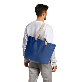 Bellroy Market Tote in navy blue recycled nylon carried over shoulder by male model