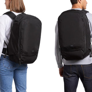 Bellroy Transit Backpack Plus in black worn by male and female models, showing durable water-resistant fabric