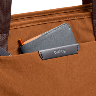 Bellroy Tokyo Tote Second Edition brown fabric tote with front pocket holding a gray wallet and pen