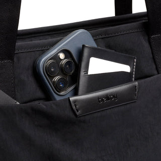 Bellroy Tokyo Tote Second Edition black tote pocket holding smartphone and leather cardholder with logo