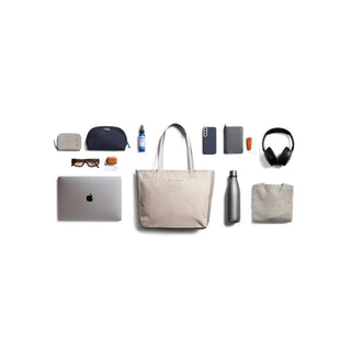 Bellroy Tokyo Tote Second Edition in light beige canvas with organized daily essentials laid out beside it