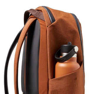 Bellroy Transit Workpack 20L (Second Edition) in brown with side pocket holding an orange water bottle