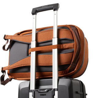 Bellroy Transit Workpack 20L (Second Edition) showing brown padded straps and back panel resting on suitcase handle