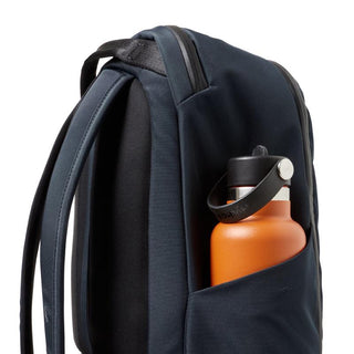 Bellroy Transit Workpack 20L (Second Edition) in dark fabric with side pocket holding an orange bottle