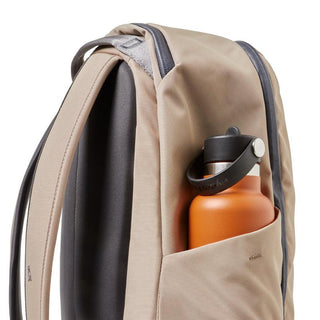 Bellroy Transit Workpack 20L (Second Edition) beige backpack with side pocket holding orange water bottle