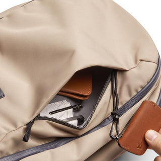 Bellroy Transit Workpack 20L (Second Edition) beige backpack with partially opened zippered pocket showing accessories
