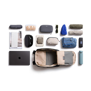 Bellroy Transit Workpack 26L in tan with organized travel essentials neatly displayed around it