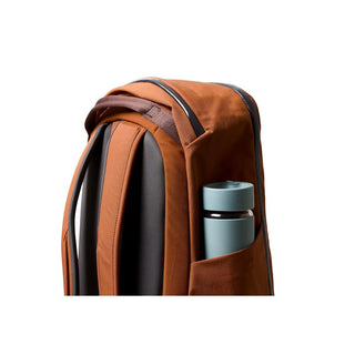 Bellroy Transit Workpack 26L in rust fabric with side pocket holding a teal water bottle