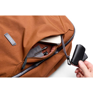 Bellroy Transit Workpack 26L in rust brown with front zip pocket holding tech and keys