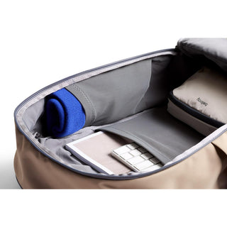 Bellroy Transit Workpack 26L open, showing organized compartments with a rolled sweater and tech accessories inside