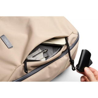 Bellroy Transit Workpack 26L beige backpack front pocket holding keys, pens, and notebook inside