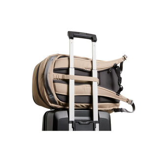 Bellroy Transit Workpack 26L beige backpack secured on black suitcase handle, padded straps visible