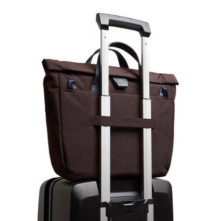Bellroy Tokyo Messenger Bag 14" in dark brown fabric secured on a suitcase handle from the back angle