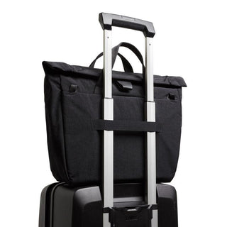 Bellroy Tokyo Messenger Bag 14" in black fabric secured on a suitcase handle for travel convenience