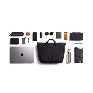 Bellroy Tokyo Messenger Bag 14" in black recycled fabric with travel and tech essentials laid out