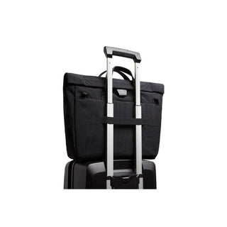 Bellroy Tokyo Messenger Bag 16" in black fabric secured on luggage handle showcasing travel convenience
