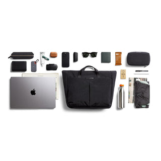 Bellroy Tokyo Messenger Bag 16 inch in black with organized daily essentials laid out on white background