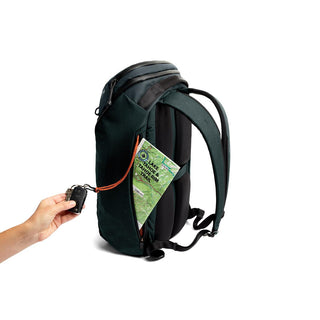Bellroy Venture Travel Pack 26L shown open with map inserted and hand holding car key beside backpack